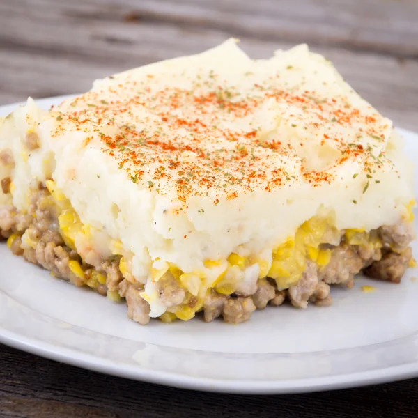 Un morceau de casserole sur une assiette blanche, représentant un repas prêt-à-manger de Meilleur repas.