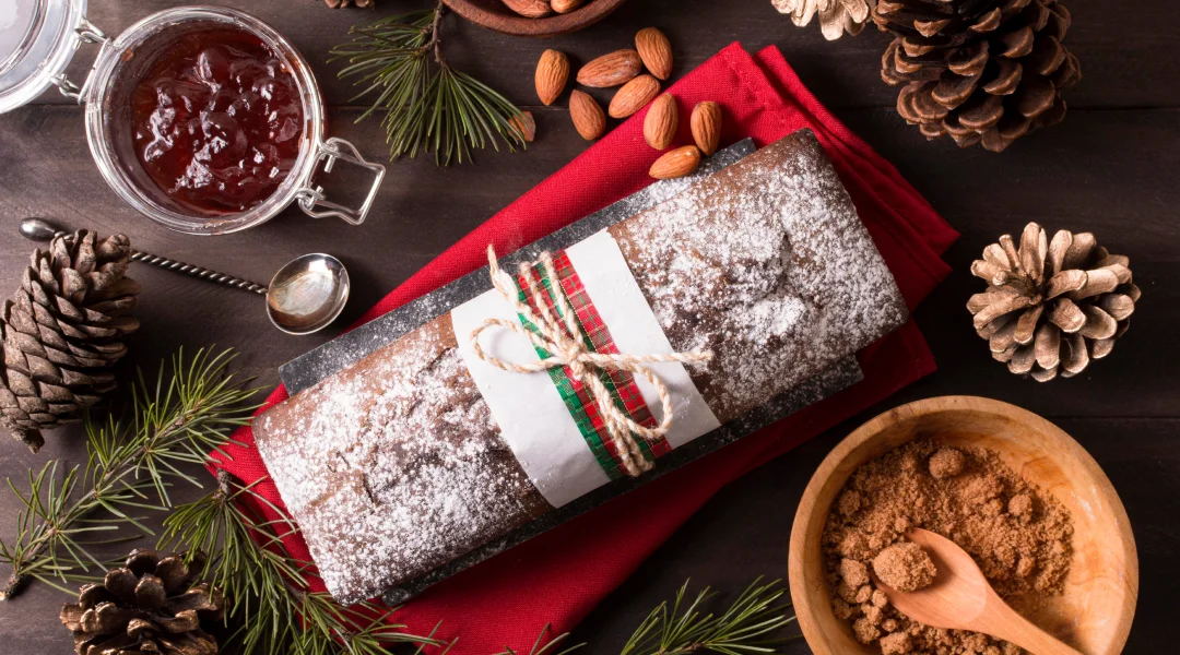 Gâteau de Noël fait maison, garni d'épices et de noix, posé sur une table en bois.