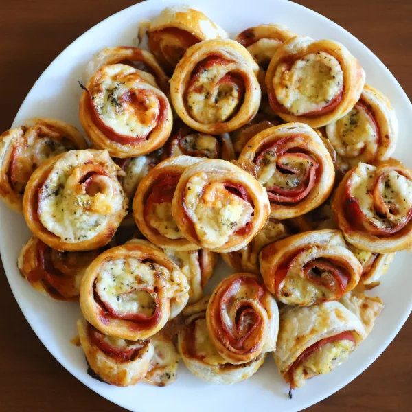 Une assiette de rouleaux de pizza sur une table, représentant un repas de Noël simple et convivial.